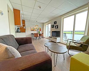 Lichtovergoten woonkamer van Appartement Bos en Duin 19 in De Dennen, Texel met moderne inrichting en uitzicht op natuur.