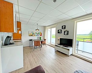 Open keuken en eetruimte in Appartement Bos en Duin 19, De Dennen, Texel met uitzicht op groene velden van de Waddeneilanden.