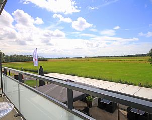 Uitzicht vanaf het balkon van Appartement Bos en Duin 19 in De Dennen, Texel met panoramisch uitzicht over de groene velden.
