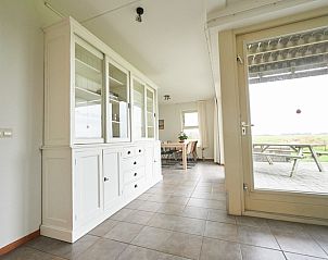 Stijlvolle eetkamer in De Mispel vakantiehuis, De Dennen, Texel met toegang tot het terras en uitzicht op de Waddeneilanden.