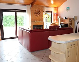 Comfortabele woonkamer met open haard in Vakantiehuis Gortersmient 300, De Dennen, Texel. Ideaal voor ontspanning op de Waddeneilanden.