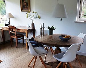 Eetruimte in De Uithof bungalow, De Dennen, Texel, met houten tafel en stijlvolle stoelen.
