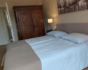 Slaapkamer met tweepersoonsbed in De Uithof bungalow, De Dennen, Texel, sfeervol ingericht.