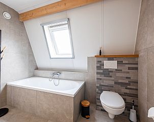 Luxe badkamer in Wulpenweid 10 de Wulp, vakantiehuis De Dennen Texel met ligbad en toilet.