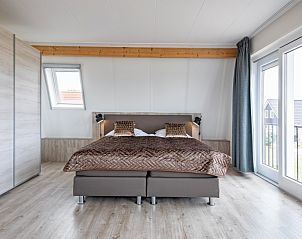 Ruime slaapkamer in Wulpenweid 10 de Wulp, vakantiehuis De Dennen Texel met balkon en veel licht.