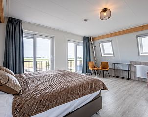 Slaapkamer met uitzicht in Wulpenweid 10 de Wulp, vakantiehuis De Dennen Texel met grote ramen.