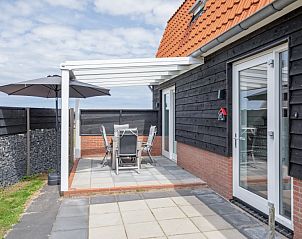 Terras met parasol in Wulpenweid 10 de Wulp, vakantiehuis De Dennen Texel voor ontspannen buiten zitten.
