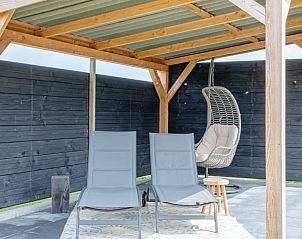 Overdekte loungehoek bij Wulpenweid 12 de Meeuw in De Dennen Texel, ideaal voor ontspanning.