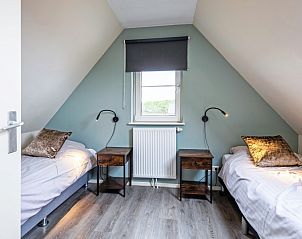 Knusse slaapkamer met twee bedden in Wulpenweid 12 de Meeuw vakantiehuis in De Dennen Texel.