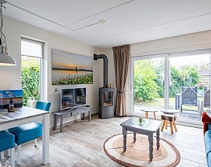 Ruime woonkamer met uitzicht op tuin in Wulpenweid 14 Zeehond, Texel.
