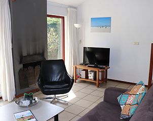 Bright living room in Holiday home Gortersmient 260, De Dennen, Texel with fireplace and TV.