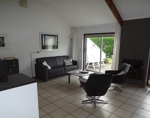 Stylish living room in Holiday Home Gortersmient 260, De Dennen, Texel with comfortable chairs and terrace.