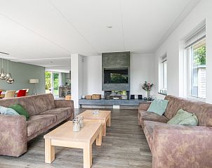 Ruime woonkamer in Villa 106F, Bungalowpark 't Hoogelandt, Texel, met moderne inrichting en open haard.