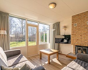 Lichte woonkamer met uitzicht op de tuin in Vakantiehuis de Parel 166, De Dennen, Texel, ideaal voor rustgevende momenten.