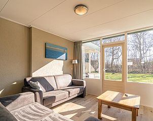 Comfortabele zithoek in Vakantiehuis de Parel 166, Texel, Bungalowpark De Parel, met veel natuurlijk licht en uitzicht op de natuur.