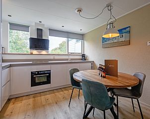 Eethoek in Vakantiehuis de Parel 166, Texel, Bungalowpark De Parel, met uitzicht op de tuin, ideaal voor gezellige maaltijden.