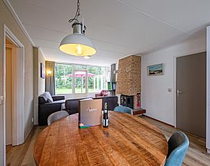 Eet- en woonkamer in Vakantiehuis de Parel 166, De Dennen, Texel, Bungalowpark De Parel, met gezellige inrichting en tuinzicht.