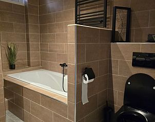 Cozy bathroom in Helianthus vacation home, De Dennen, Texel with bathtub.