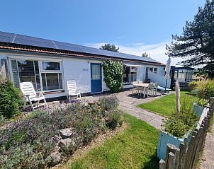 Sunny terrace at Boszicht vacation home in De Dennen, Texel with comfortable chairs.