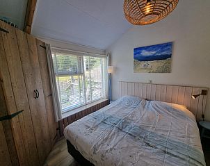 Attractive bedroom in Boszicht vacation home, De Dennen, Texel with wooden details.