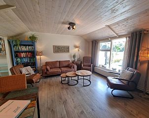 Cozy living room of Boszicht vacation home in De Dennen, Texel with leather sofas.