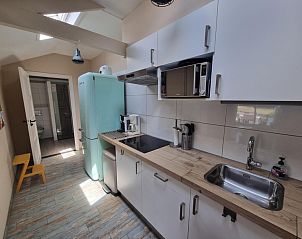 Kitchen of Boszicht vacation home in De Dennen, Texel with retro fridge and light.
