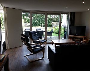 Lichte woonkamer van Bollenveld - de Iris, vakantiehuis in De Dennen, Texel met toegang tot terras.