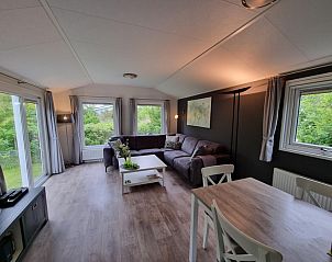 Vakantiepark de Bremakker, Texel: Cozy living room of vacation home in De Dennen with garden view.