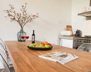 Dining table in kitchen of Bungalowpark Oud Vredelust - Zeeskuum, Texel with fruit and wine