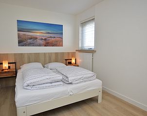 Schnes Schlafzimmer mit Kunstwerken im Bungalowpark 't Luwe Land - Bungalow 13c, De Dennen, Texel, fr eine gute Nachtruhe.