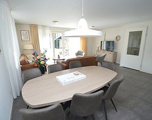 Dining area in Holiday home de Parel 190, Texel, with large table and comfortable chairs for cozy meals.