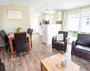 Spacious indoor room with dining and sitting area in Holiday Park De Koorn-aar Type F, Texel, Wadden Islands.