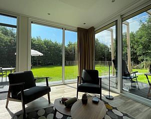 Gezellige binnenruimte van Huisje in Formerum Terschelling, met uitzicht op de groene tuin van de Waddeneilanden.