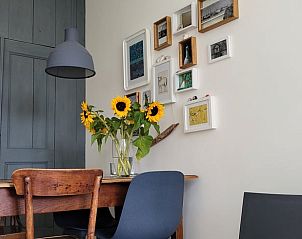 Stylish dining area in Holiday Home in Formerum Terschelling with flowers and art.