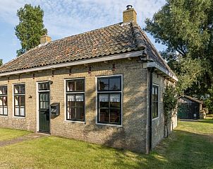 Charmante voorgevel van Meiblok vakantiehuis in Formerum, Terschelling omringd door groene natuur.