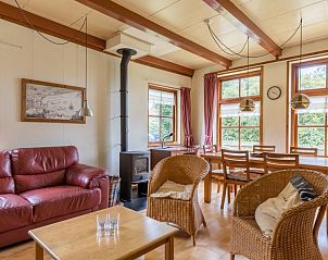 Eetkamer van Meiblok vakantiehuis in Formerum, Terschelling met grote ramen en houten eettafel.