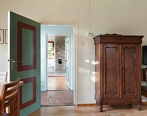 Interieur van Meiblok vakantiehuis in Formerum, Terschelling met traditionele kast en open deur naar hal.