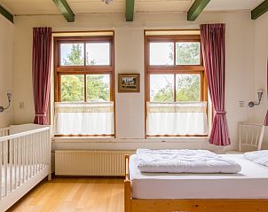 Gezinsvriendelijke slaapkamer met ledikant in Meiblok vakantiehuis in Formerum, Terschelling.