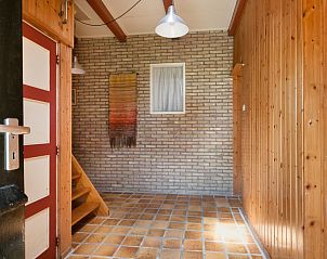 Entreehal van Meiblok vakantiehuis in Formerum, Terschelling met bakstenen muur en houten afwerking.