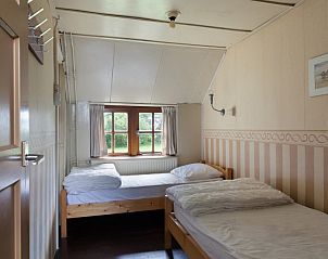 Gezellige slaapkamer in Meiblok vakantiehuis in Formerum, Terschelling met twee bedden en raam.