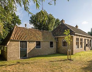 Achtertuin van Meiblok vakantiehuis in Formerum, Terschelling met groene omgeving en bomen.