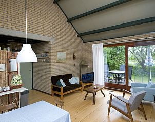 Lichte woonkamer met schuifpui naar terras in Huis van Gregorius, vakantiehuis in Formerum, Terschelling.