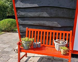 Rode bank bij vakantiehuis De Trekvogels in Formerum, Terschelling voor ontspannen momenten.