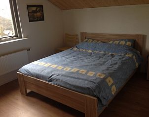 Comfortabele slaapkamer in De Trekvogels, vakantiehuis in Formerum, Terschelling met houten meubilair.