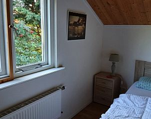 Sfeervolle slaapkamer in De Trekvogels, vakantiehuis in Formerum, Terschelling met uitzicht op de tuin.