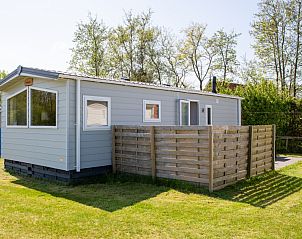 Buitenzijde van chalet Rhobin, een vakantieverblijf in Formerum, Terschelling omgeven door groen.