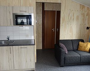 Knusse zithoek in Noorderlicht vakantiehuis, Formerum, Terschelling met bank en kussens.