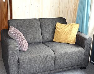 Comfortabele bank in Noorderlicht vakantiehuis, Formerum, Terschelling met kleurrijke kussens.