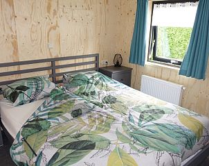Slaapkamer in Noorderlicht vakantiehuis, Formerum, Terschelling met tweepersoonsbed en raam.