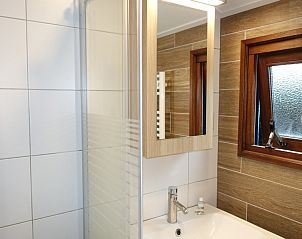 Badkamer in Noorderlicht vakantiehuis, Formerum, Terschelling met moderne wastafel en spiegel.